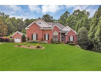 Charming two-story brick home featuring lush green lawn, manicured landscaping, and attached two-car garage at 4119 Alayna Lee Cir, Mcdonough, GA 30252