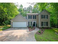 Traditional two-story home with a two-car garage, manicured lawn, and mature trees at 5679 Bay Harbor Nw Trl, Acworth, GA 30101