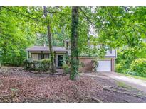 Charming two-story home with a brick and siding exterior and a well-maintained lawn surrounded by mature trees at 3694 Rolling Pl, Conley, GA 30288
