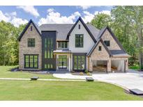 A beautiful two-story brick home featuring a three-car garage and a well-manicured lawn and garden at 4459 Grady Smith Rd, Loganville, GA 30052