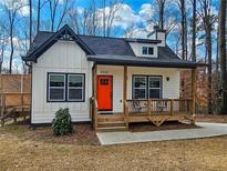 Charming home featuring a bright orange door, inviting front porch and stylish black and white accents at 5728 Williams Rd, Norcross, GA 30093