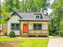 Charming cottage-style home featuring a welcoming front porch and a vibrant orange front door at 5728 Williams Rd, Norcross, GA 30093