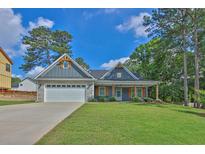Charming single-story home featuring stone accents, a two-car garage, and a beautifully landscaped front yard at 145 Millennial Ct, Lawrenceville, GA 30045