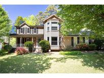Charming two-story home featuring a welcoming porch and lush landscaping at 2889 Carrousel Ct, Stone Mountain, GA 30087