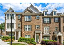 Charming brick townhome with gabled roof, neutral shutters, and lush landscaping at 1174 City Park Ln, Decatur, GA 30033