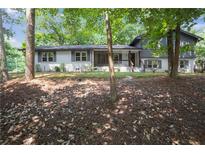 Charming two-story home featuring a mix of painted brick and siding, complemented by mature trees and manicured landscaping at 2445 Kings Point Dr, Dunwoody, GA 30338
