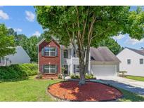 Charming two-story home with brick and siding exterior, mature tree, and well-maintained lawn at 3234 Baymount Way, Lawrenceville, GA 30043