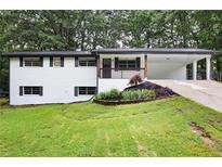 Charming single-Gathering home with a brick exterior, manicured front lawn, and covered carport at 4651 Palm Dr, Douglasville, GA 30135
