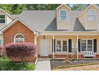 Charming townhome with brick accents, front porch and beautiful landscaping at 1062 Sasha Ln, Roswell, GA 30075
