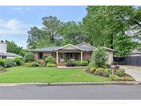Charming brick home with a well-manicured lawn and lush landscaping adding curb appeal at 236 Ridge Nw Ave, Marietta, GA 30064