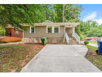 Charming single-story home with a brick facade, concrete driveway, and landscaped front yard at 1381 Benteen Way Southeast, Atlanta, GA 30315
