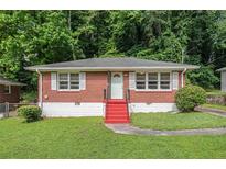 Charming red brick home with bright red stairs and a well-maintained lawn in a tree-lined neighborhood at 2329 Polar Rock Sw Ave, Atlanta, GA 30315