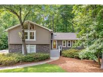 Charming home featuring stone accents, a well-manicured lawn, and a walkway leading to the front door at 2717 Hearthstone Cir, Marietta, GA 30062