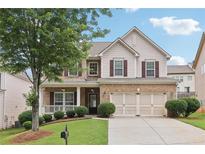 Charming two-story home with brick and siding, attached two-car garage, and manicured landscaping at 230 Collins View Ct, Lawrenceville, GA 30043