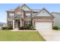 Traditional brick home with a well-manicured lawn and a two-car attached garage at 2537 Sori Dr, Buford, GA 30519