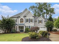 Charming two-story home with beautiful landscaping, manicured lawn and classic architectural details at 525 Arbor Creek Ct, Roswell, GA 30076