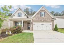 Charming brick home with a two-car garage and beautifully landscaped front yard at 160 Amherst Way, Fayetteville, GA 30215
