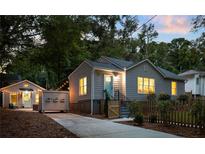 Charming home with a fenced yard, featuring a blue front door and tasteful landscaping at 1583 Braeburn Se Dr, Atlanta, GA 30316