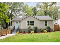 Charming home with a well-maintained lawn, complemented by freshly mulched flower beds and a cheerful light blue front door at 1583 Braeburn Se Dr, Atlanta, GA 30316