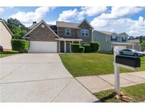 Beautiful two-story home with stone accents, well-manicured lawn, and a spacious driveway at 211 Augusta Woods Dr, Villa Rica, GA 30180