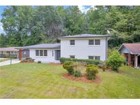 Charming white brick home with manicured lawn and mature trees providing a picturesque setting at 2678 Rainbow Forest Dr, Decatur, GA 30034