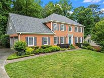 Beautiful two-story brick home with manicured lawn and lovely landscaping with a blue front door at 4792 Fairville Ct, Marietta, GA 30062