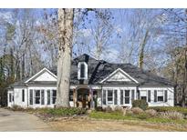 Charming single-Gathering home with a manicured front yard and classic architectural details and mature trees at 6170 Wellington Ct, Cumming, GA 30040