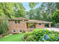 Charming brick home with a well-manicured front yard featuring lush greenery and colorful hydrangea bushes at 1706 Remington Rd, Atlanta, GA 30341