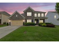 Charming two-story brick home with a well-manicured lawn and welcoming front porch at 7190 Tributary Ct, Cumming, GA 30040