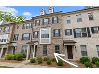 Attractive brick townhome featuring black shutters and manicured landscaping at 2022 Talmai Dr, Snellville, GA 30078