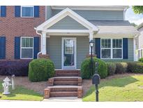 Charming home entrance features brick steps, manicured shrubs and a stylish glass front door at 577 Cypher Drive, Suwanee, GA 30024