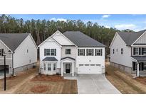 Beautiful two-story home with a two-car garage, landscaped front yard and black shutters at 13567 Whitman Lane, Covington, GA 30014