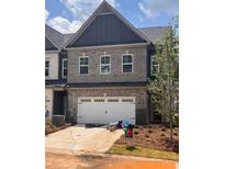 Charming new construction townhome with a one-car garage and a mix of gray brick and siding at 3102 Marbella Cir # 1, Kennesaw, GA 30152