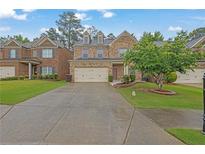 Charming two-story brick home with a well-manicured lawn and two-car garage at 7027 Walham Grv, Duluth, GA 30097