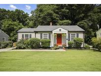 Charming single-story home featuring a well-maintained lawn and a welcoming red front door with a wreath at 1385 Kenilworth Sw Dr, Atlanta, GA 30310