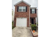 Charming brick home featuring a single car garage and well maintained landscaping at 2080 Belmont Cir, Conyers, GA 30012