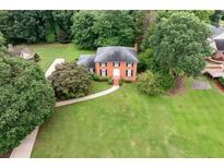Inviting brick home with black shutters, mature landscaping, and expansive green lawn at 3589 Stone Ridge Trl, Douglasville, GA 30134