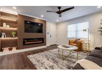 Stylish living room features a modern fireplace, sleek ceiling fan, and decorative wood accent wall with built-in shelving at 4282 Roswell Ne Rd # G1, Atlanta, GA 30342