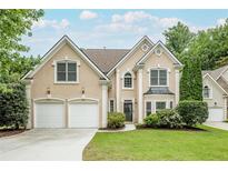 Charming home with a well-manicured lawn, two-car garage, and neutral stucco facade at 1921 Northbrooke Ln, Dunwoody, GA 30338