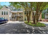 Inviting condo complex with tan siding, green trees, and a well-maintained lawn at 2214 Lake Pointe Cir, Roswell, GA 30075