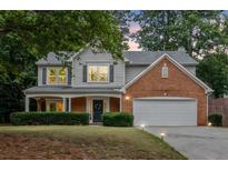 Charming two-story home featuring a brick facade, a covered porch and a manicured lawn at 2711 Brookefield Nw Ln, Kennesaw, GA 30152