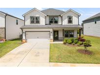 Charming two-story home boasts a pristine lawn, two-car garage, and welcoming front porch at 4720 Dufour Dr, Lilburn, GA 30047