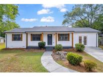 Charming home featuring a manicured lawn, wood accents, and a stone walkway leading to the front door at 2657 John Petree Rd, Powder Springs, GA 30127