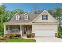 Charming single-Gathering home featuring a covered front porch, stone accents, and a two-car garage at 520 Edgemore Rd, Canton, GA 30114