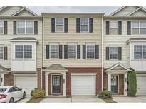 Attractive townhome featuring tan siding, brick accents, black shutters, attached garages and a welcoming front entrance at 6895 Slate Stone Se Way # 3, Mableton, GA 30126