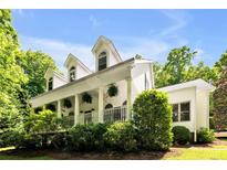 Charming home featuring a columned front porch with hanging plants and dormer windows at 7212 Avalon Dr, Douglasville, GA 30135