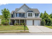 Charming two-story home with a well-manicured lawn and a two-car garage at 895 Roxfield Ct, Buford, GA 30518
