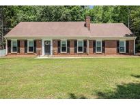 Charming ranch-style home with brick facade, black shutters, and a well-maintained front yard at 1828 Brandy Woods Se Dr, Conyers, GA 30013
