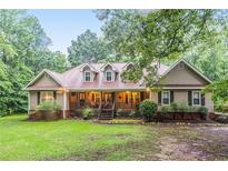 Charming ranch-style home features a welcoming front porch and well-maintained landscaping at 324 Kibbee Rd, Mcdonough, GA 30252