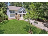 Charming two-story home featuring a manicured lawn and attached two-car garage at 835 Navajo Trl, Covington, GA 30016